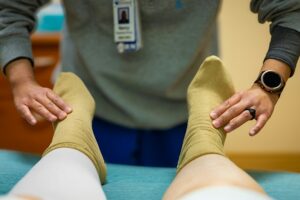 Health worker fitting compression stockings