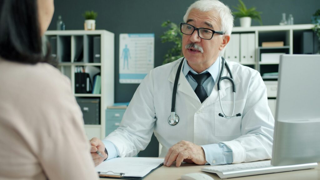 Physician talking with a patient across his desk