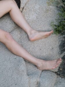 Legs resting outdoors on stone